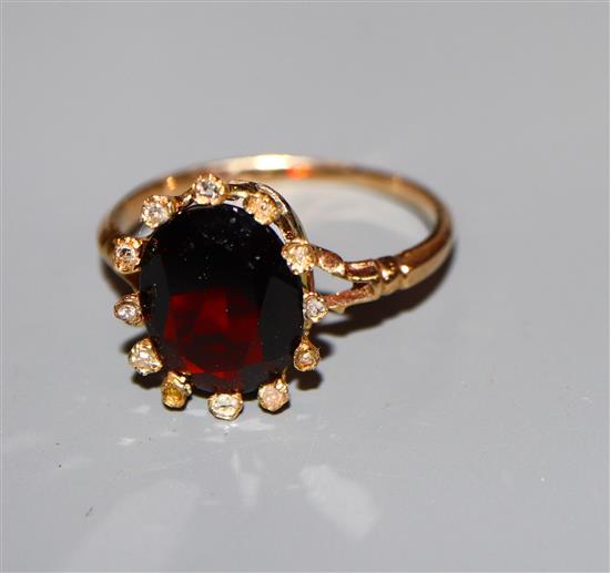 A yellow metal, garnet and diamond set cluster ring, size K.